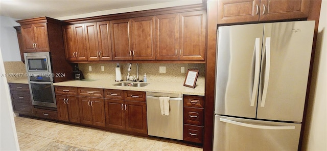 kitchen featuring sink, appliances with stainless steel finishes, decorative backsplash, and light tile patterned floors