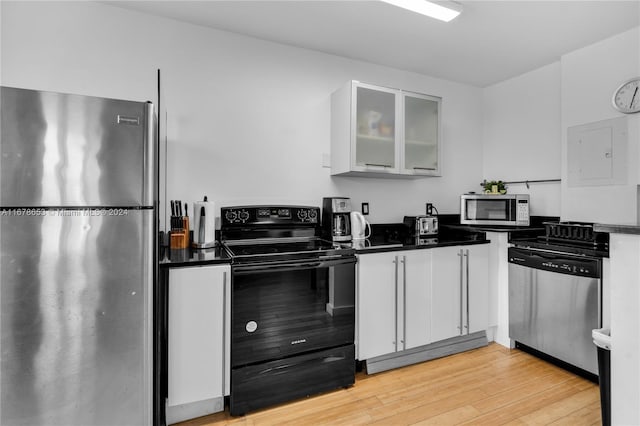 kitchen featuring electric panel, light hardwood / wood-style flooring, stainless steel appliances, and white cabinets