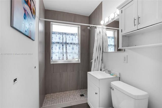 bathroom featuring toilet, a shower with curtain, vanity, and tile patterned flooring