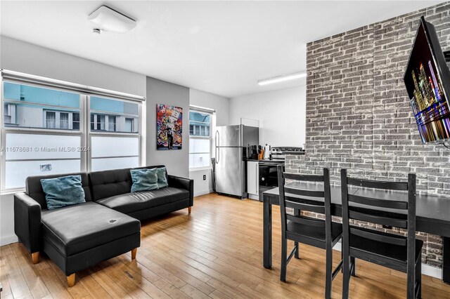 1512 Washington Ave Unit 203, Miami Beach, FL 33139 - living area with wood-type flooring and brick wall