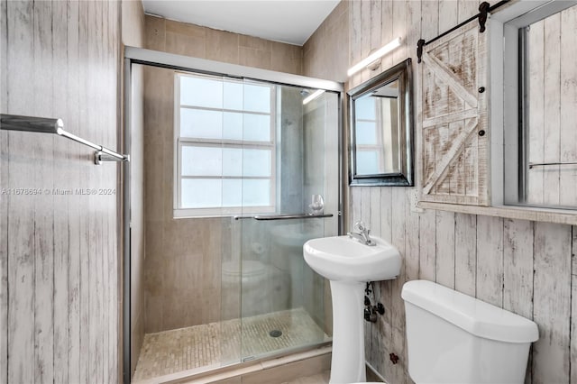 bathroom featuring wooden walls, toilet, and an enclosed shower