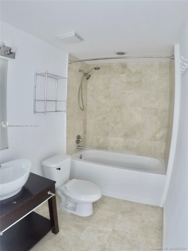 full bathroom featuring tiled shower / bath combo, toilet, and vanity