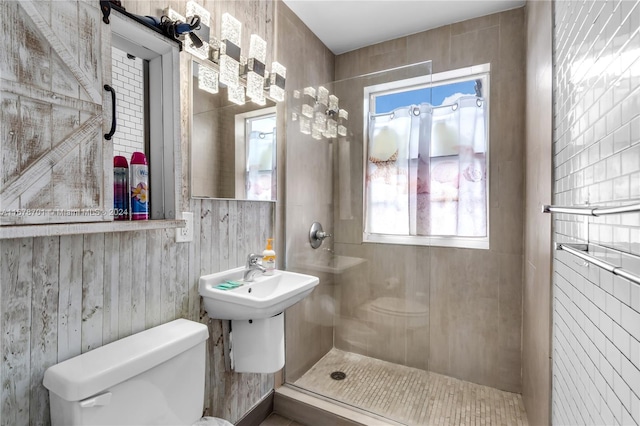 bathroom with a tile shower and toilet