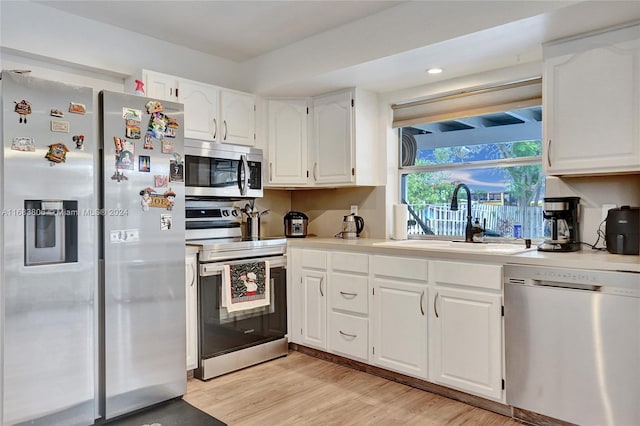 kitchen with white cabinetry, appliances with stainless steel finishes, sink, and light hardwood / wood-style flooring