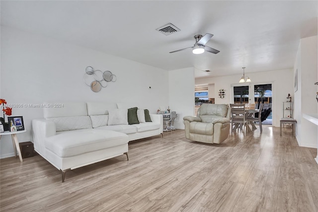 living room featuring hardwood / wood-style floors and ceiling fan with notable chandelier