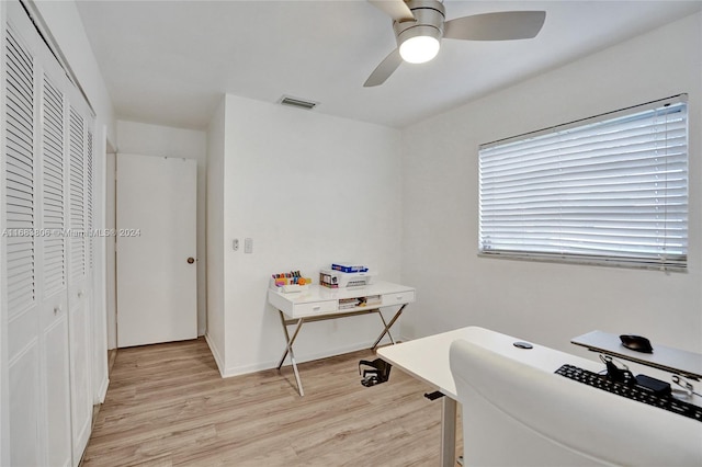 home office with light wood-type flooring and ceiling fan