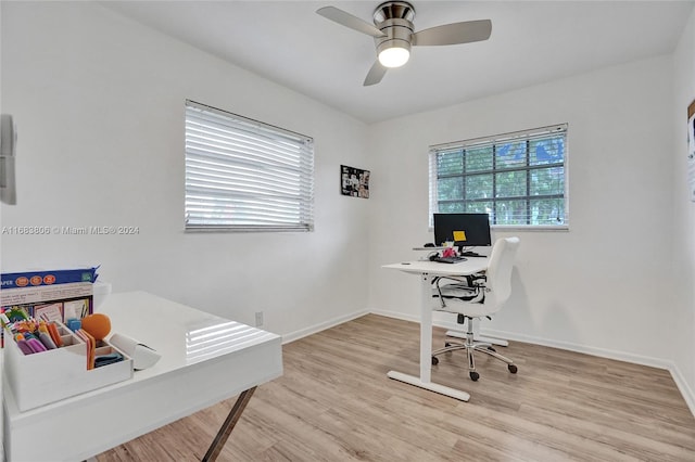 home office with light hardwood / wood-style floors and ceiling fan