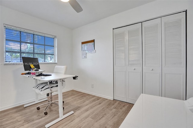 office with light wood-type flooring and ceiling fan