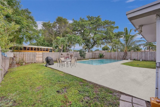 view of pool with a patio area and a yard