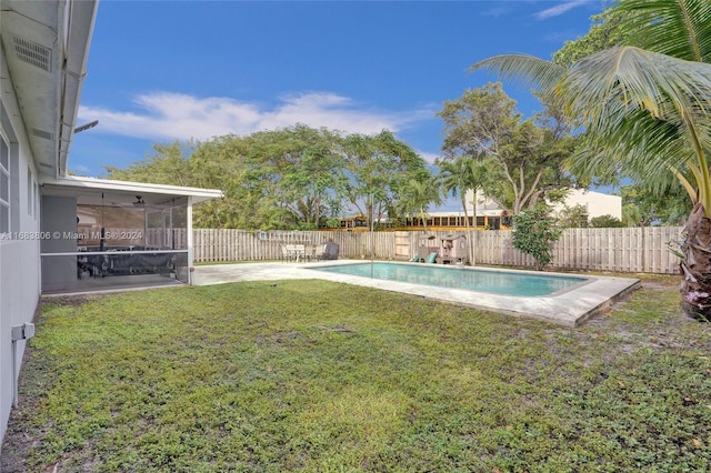 view of yard with a sunroom and a fenced in pool