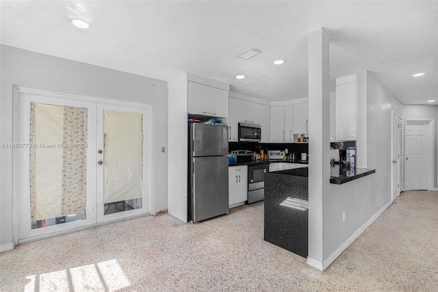 kitchen with stainless steel appliances, tasteful backsplash, and white cabinets