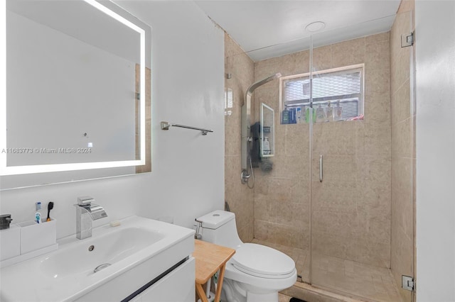 bathroom featuring vanity, toilet, and a shower with door