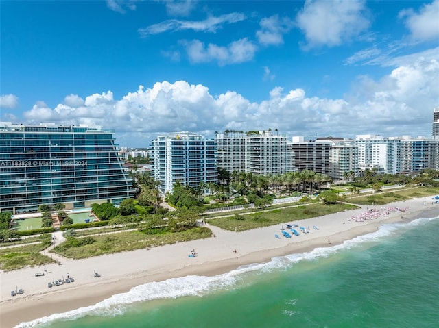 birds eye view of property featuring a water view and a beach view