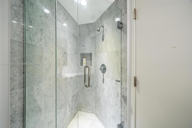 bathroom featuring a shower with door