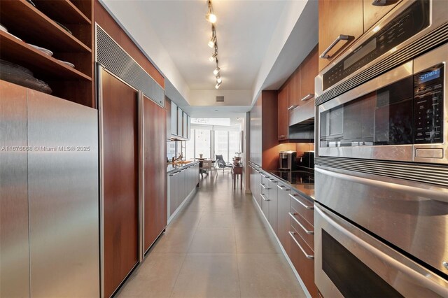 kitchen with paneled built in refrigerator and multiple ovens