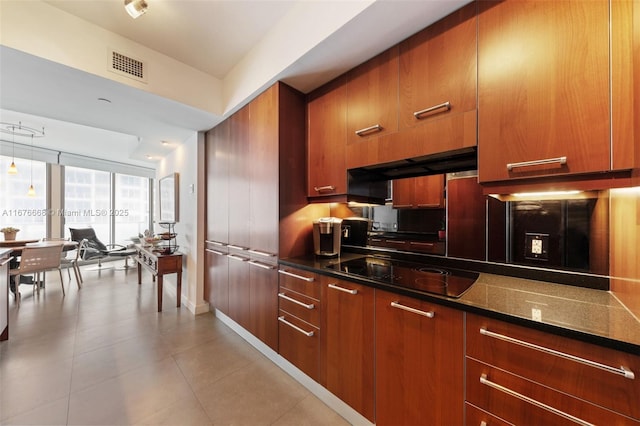 kitchen with light tile patterned floors, floor to ceiling windows, ventilation hood, black electric cooktop, and dark stone counters