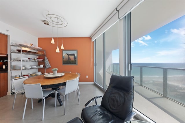 dining space featuring a water view and floor to ceiling windows