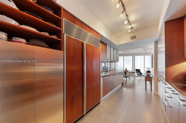 kitchen with paneled built in refrigerator and stainless steel counters