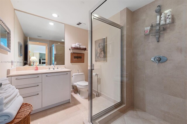 bathroom featuring toilet, tile patterned floors, an enclosed shower, and vanity