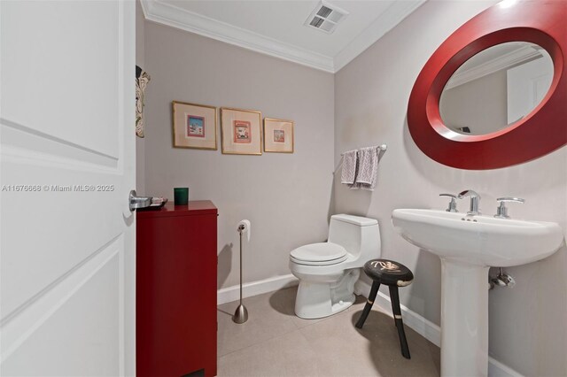 bathroom with toilet, tile patterned flooring, and crown molding