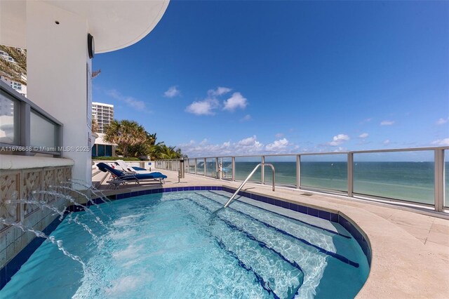 view of swimming pool with a view of the beach, a patio area, and a water view