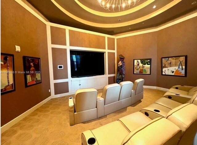 home theater with an inviting chandelier and a tray ceiling