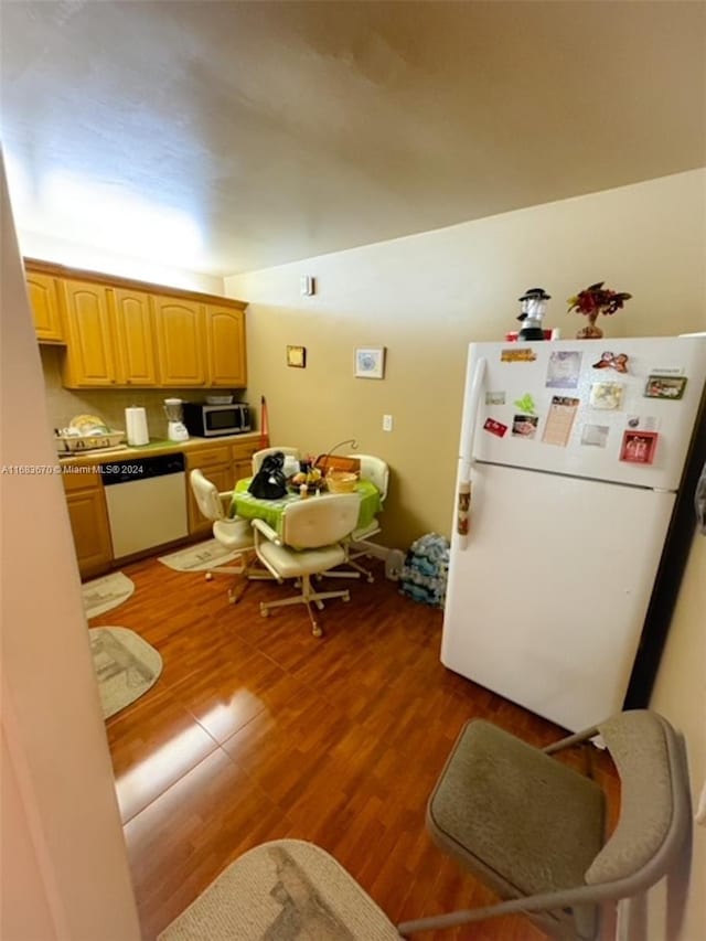 kitchen featuring hardwood / wood-style floors and white appliances