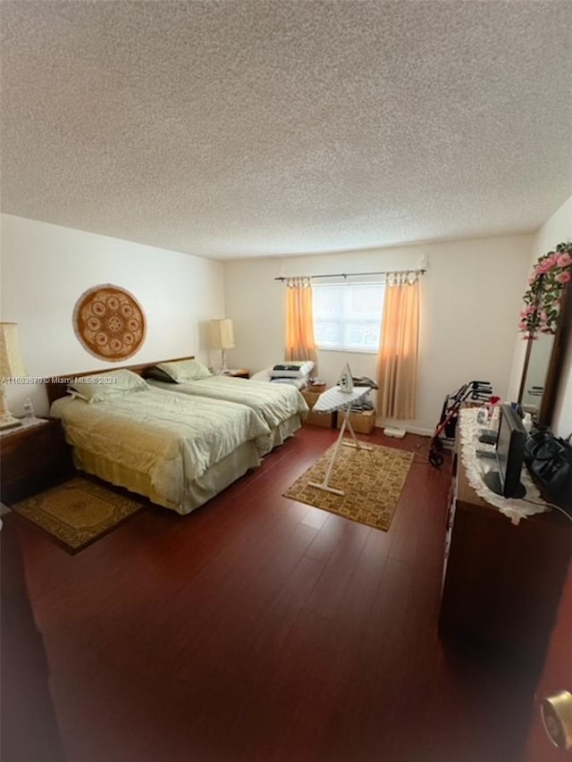 bedroom featuring a textured ceiling and dark hardwood / wood-style floors