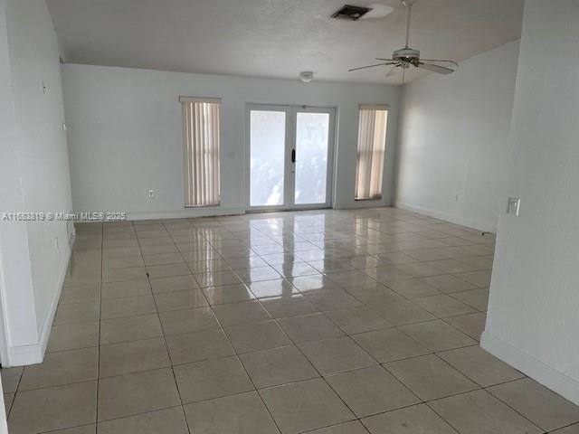 tiled spare room with french doors and ceiling fan