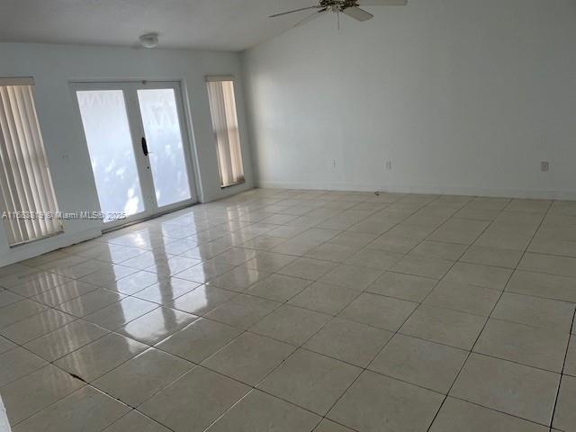 spare room with french doors, ceiling fan, and light tile patterned floors