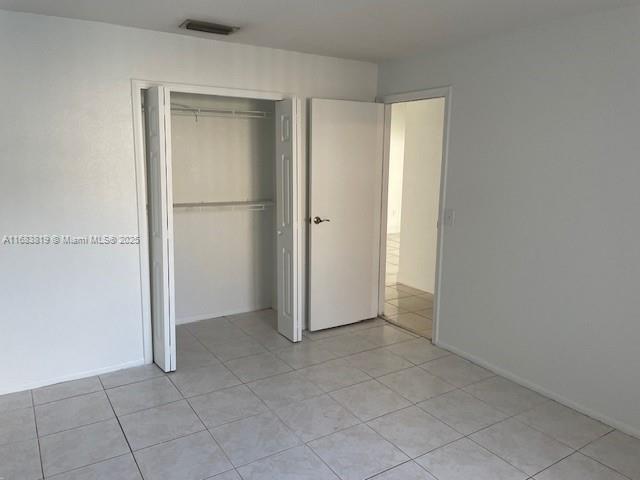 unfurnished bedroom with a closet and light tile patterned floors