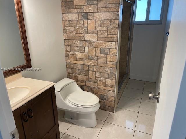 bathroom featuring vanity, an enclosed shower, tile patterned floors, and toilet