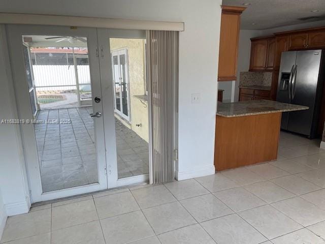 kitchen featuring stainless steel fridge with ice dispenser, backsplash, light tile patterned floors, kitchen peninsula, and french doors