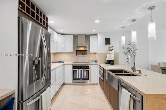 kitchen with stainless steel appliances, wall chimney exhaust hood, sink, and white cabinets