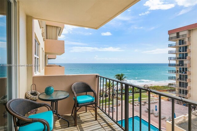 balcony featuring a water view and a view of the beach