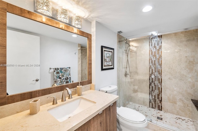 bathroom featuring vanity, toilet, and a shower with shower door