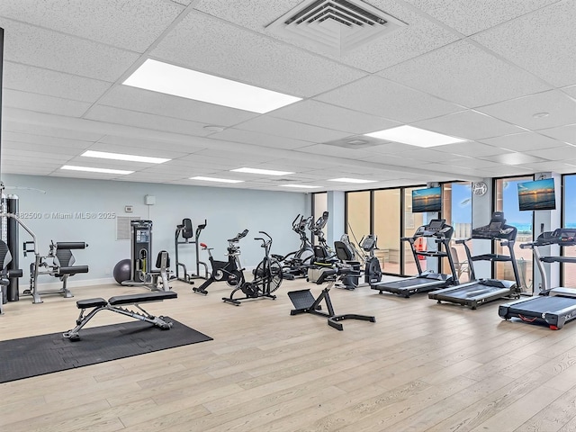 exercise room with a wall of windows and hardwood / wood-style floors