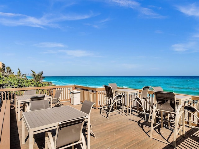 wooden deck with a water view and a view of the beach