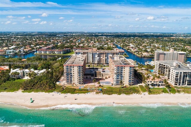 birds eye view of property featuring a water view and a beach view