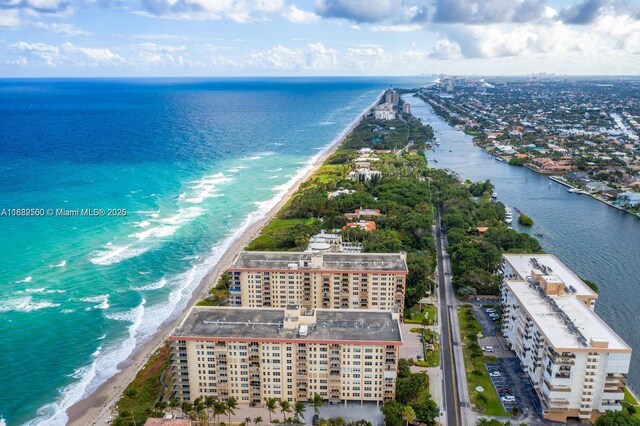 drone / aerial view with a water view and a beach view