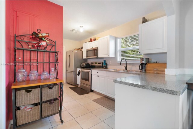 kitchen featuring sink, white cabinets, stainless steel appliances, and light tile patterned floors