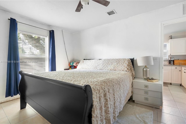 bedroom with light tile patterned flooring, connected bathroom, and ceiling fan