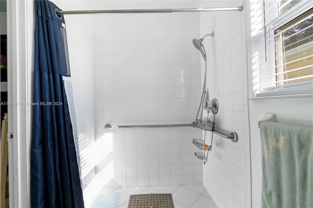 bathroom featuring tile patterned flooring and tiled shower