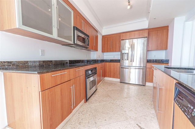 kitchen featuring appliances with stainless steel finishes, dark stone counters, crown molding, and sink