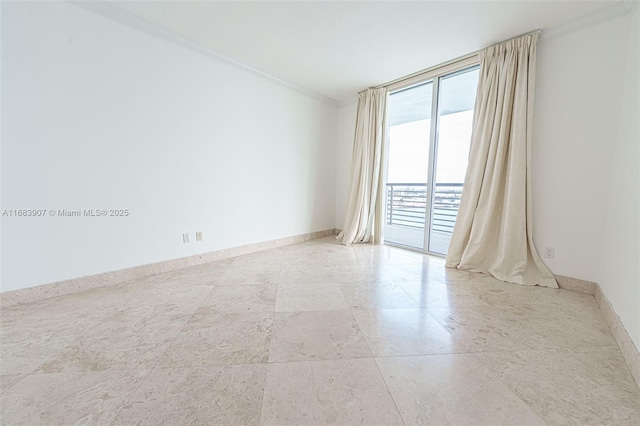 spare room featuring ornamental molding and floor to ceiling windows