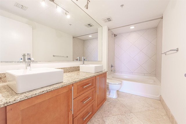 full bathroom featuring tiled shower / bath combo, vanity, and toilet