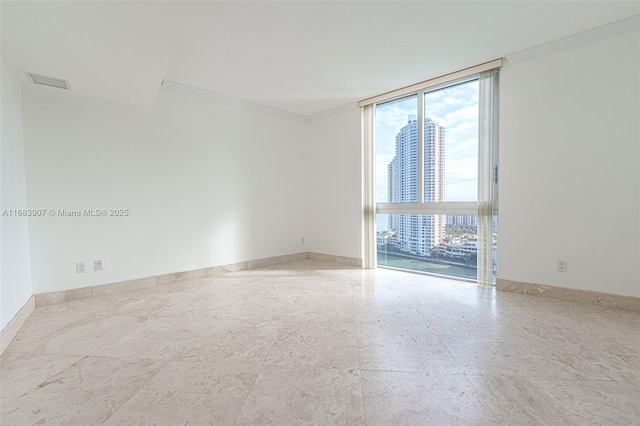 spare room featuring a wall of windows and crown molding