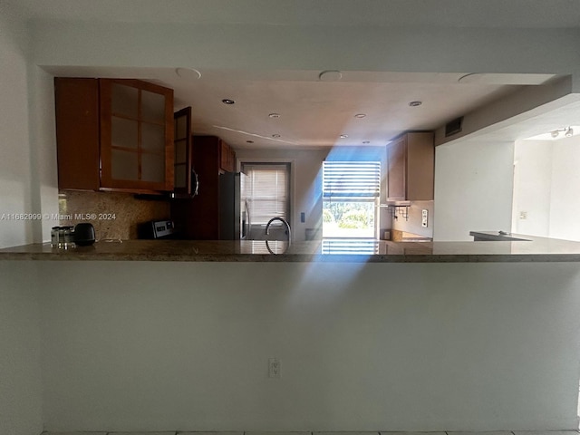 kitchen featuring kitchen peninsula, appliances with stainless steel finishes, backsplash, and sink