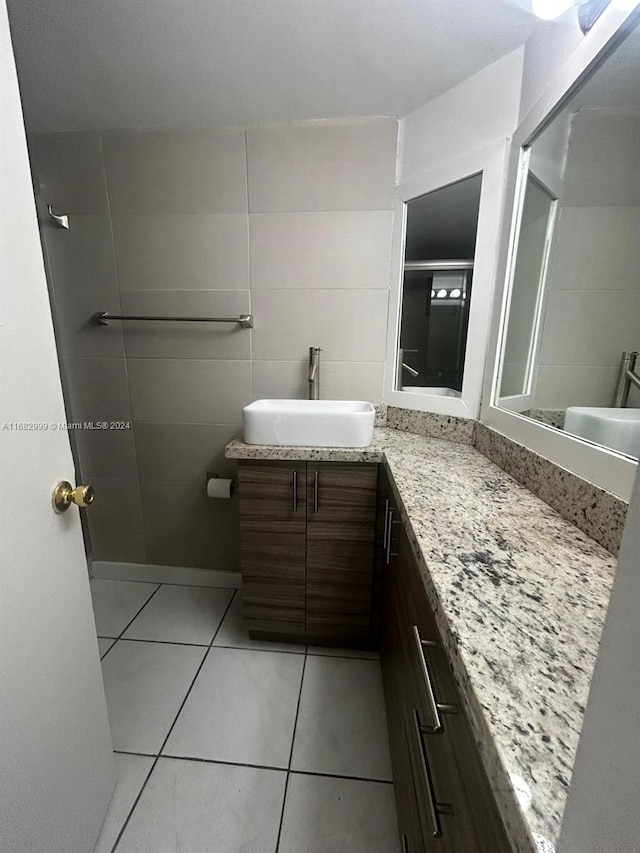 bathroom featuring tile patterned flooring, vanity, and tile walls