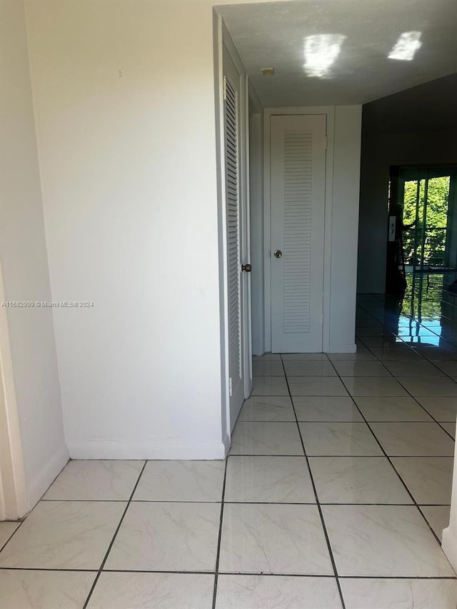 hall with light tile patterned floors